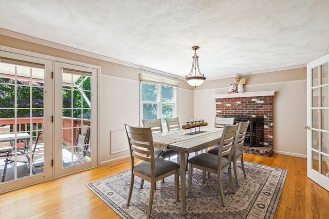 2 Strawstone Ln, Norton, MA 02766 - dining room featuring crown molding, a textured ceiling, a brick fireplace, and wood finished floors