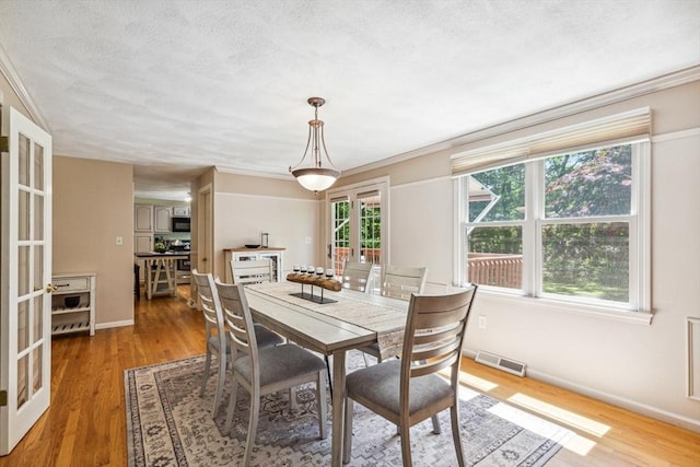2 Strawstone Ln, Norton, MA 02766 - dining area with french doors, light wood-style floors, a textured ceiling, baseboards, and crown molding