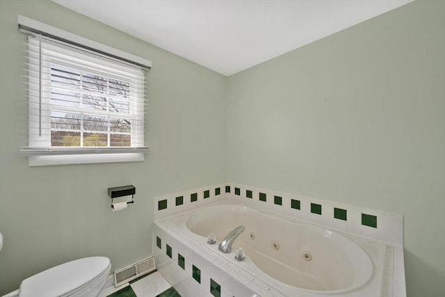 bathroom featuring a jetted tub, toilet, and visible vents