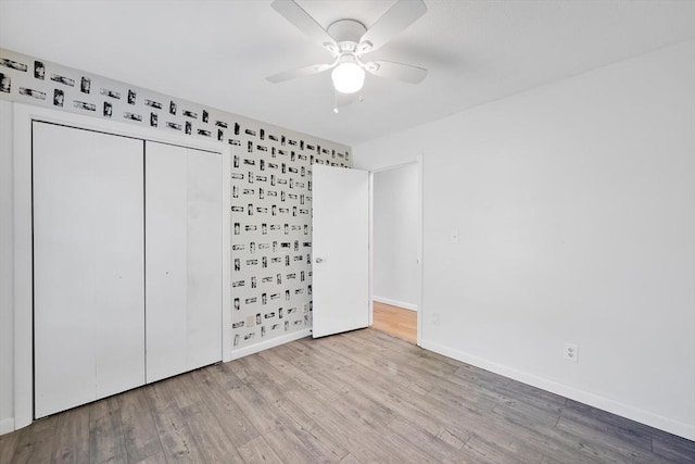 unfurnished bedroom with baseboards, wood finished floors, and a closet