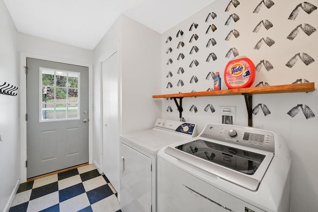clothes washing area with separate washer and dryer, laundry area, light floors, and baseboards