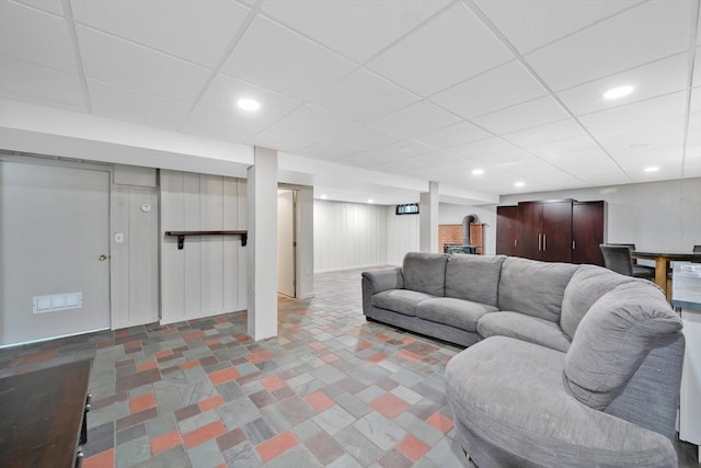 living area featuring recessed lighting, a drop ceiling, and a wood stove