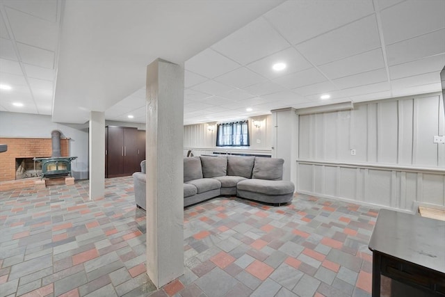 living room featuring a decorative wall, a wood stove, and recessed lighting