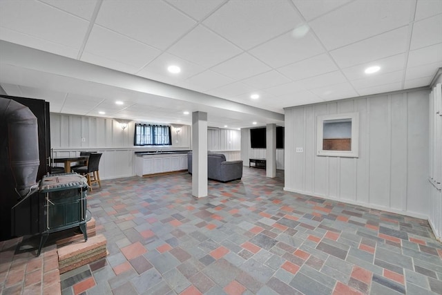 below grade area with a drop ceiling and a decorative wall
