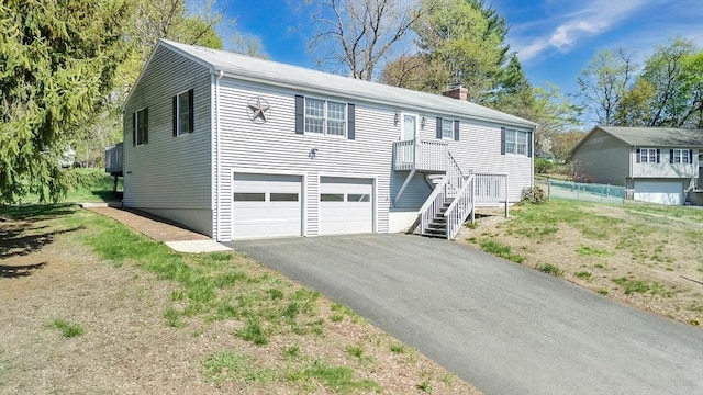 view of front of home with an attached garage, fence, driveway, and a chimney