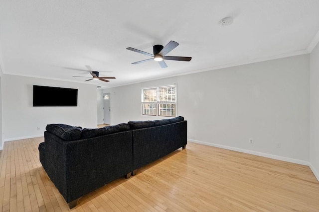living room featuring light wood-style floors, baseboards, and ornamental molding