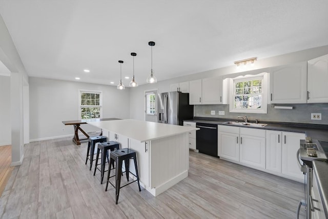 kitchen with plenty of natural light, a sink, appliances with stainless steel finishes, and a kitchen bar