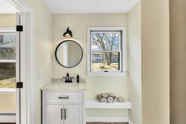 bathroom with vanity, a wealth of natural light, and a baseboard radiator