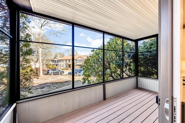 unfurnished sunroom with plenty of natural light and a residential view