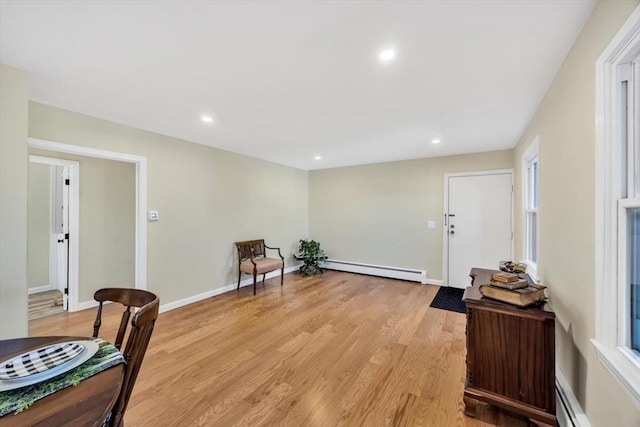 sitting room featuring recessed lighting, a baseboard heating unit, and light wood-style floors