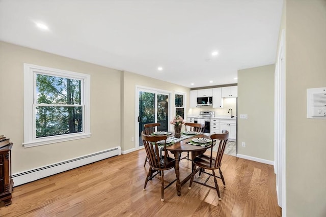 dining area featuring recessed lighting, a baseboard radiator, baseboards, and light wood-style floors