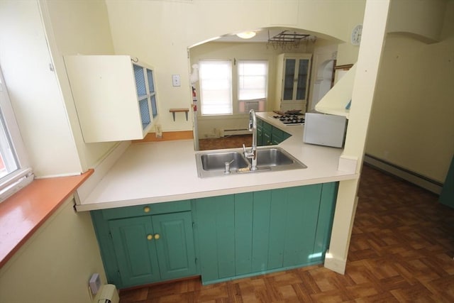 kitchen with dark parquet flooring, a baseboard radiator, a notable chandelier, and sink