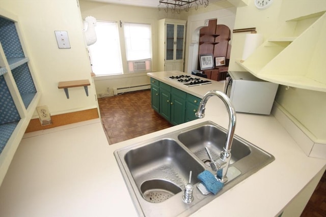 kitchen featuring white gas cooktop, refrigerator, sink, green cabinetry, and baseboard heating