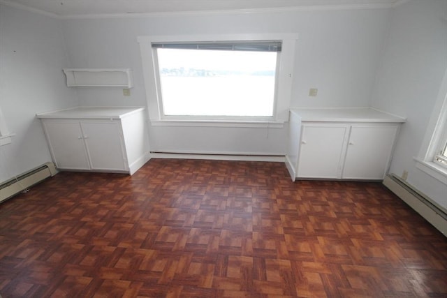 empty room with dark parquet floors, baseboard heating, and ornamental molding