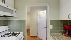 kitchen featuring white cabinets and white appliances