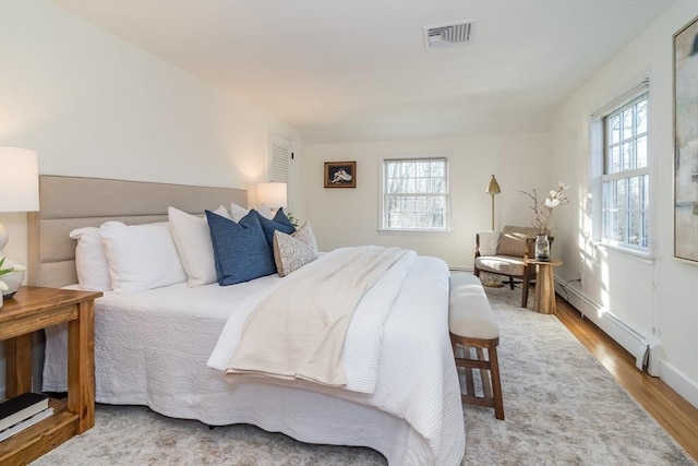 bedroom featuring light hardwood / wood-style flooring and a baseboard radiator