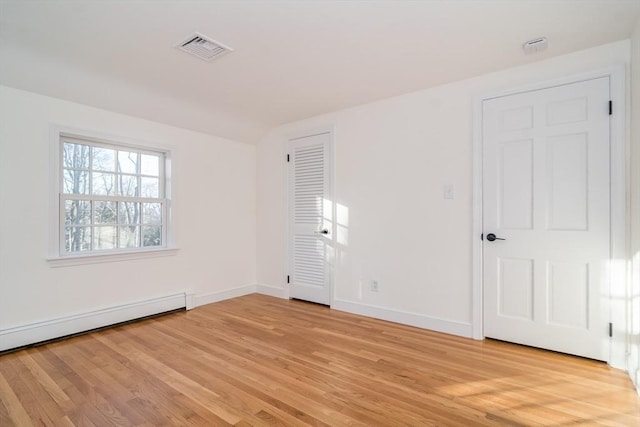 spare room featuring light hardwood / wood-style floors and a baseboard heating unit