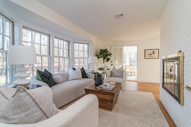 living room with brick wall and light wood-type flooring