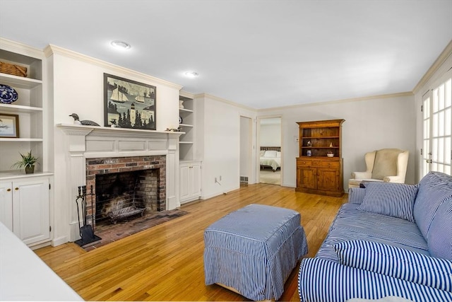 53 Wingfoot Dr, Barnstable, MA 02675 - living area with a fireplace, light wood-style floors, ornamental molding, built in features, and baseboards