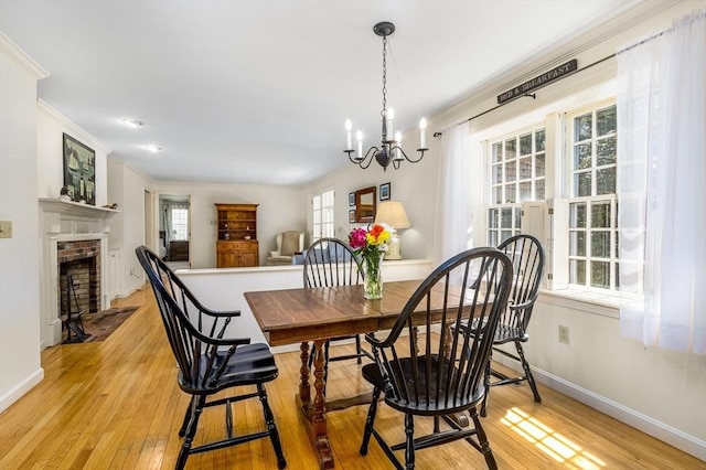 53 Wingfoot Dr, Barnstable, MA 02675 - dining room featuring light wood-type flooring, a chandelier, baseboards, a fireplace, and ornamental molding