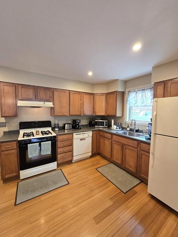 94 Barton St Unit 3, Pawtucket, RI 02860 - kitchen featuring white appliances, under cabinet range hood, a sink, dark countertops, and recessed lighting
