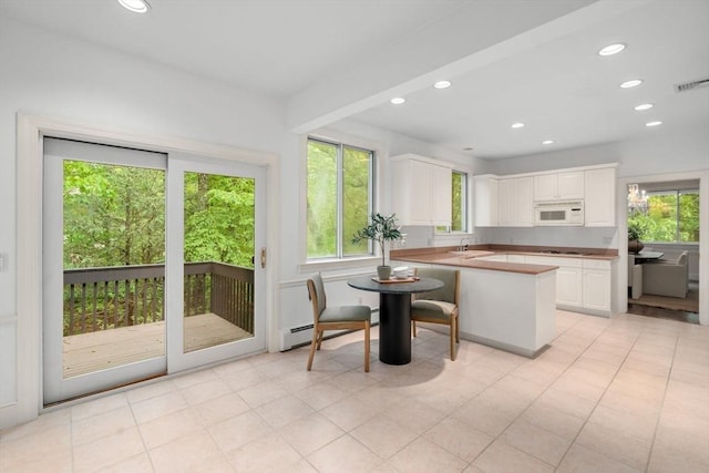 204 Allandale Rd Unit A, Boston, MA 02467 - kitchen featuring white microwave, a sink, white cabinetry, recessed lighting, and a peninsula