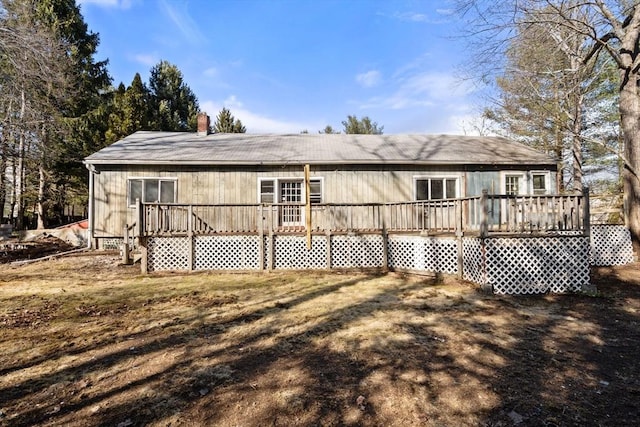 rear view of house featuring a deck and a chimney