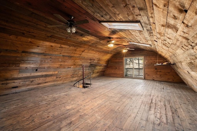 bonus room with vaulted ceiling with skylight, wood walls, wooden ceiling, and wood-type flooring