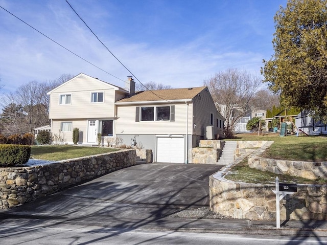 view of front of home with a playground, a garage, and a front lawn