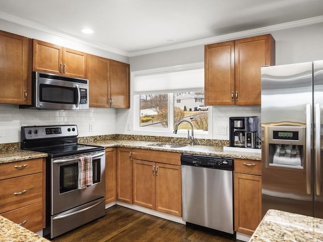 kitchen with light stone countertops, sink, stainless steel appliances, dark hardwood / wood-style floors, and ornamental molding