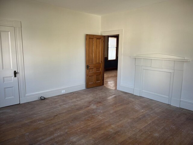 unfurnished room with dark hardwood / wood-style flooring