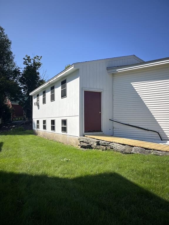 property entrance with a lawn