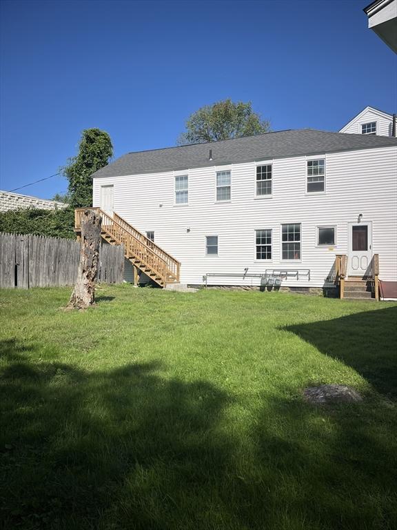 rear view of house featuring a yard