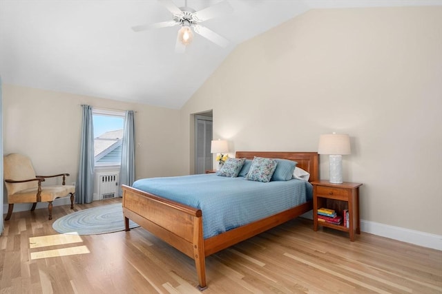 bedroom with a ceiling fan, baseboards, light wood finished floors, lofted ceiling, and radiator heating unit