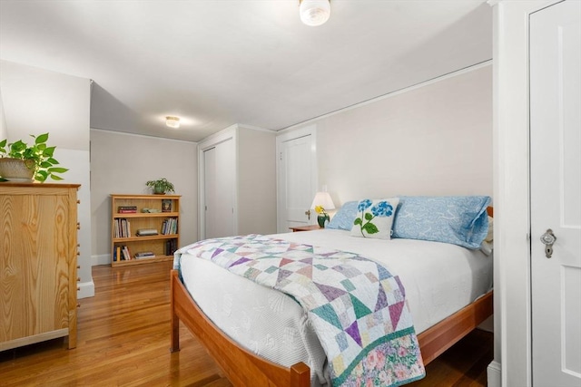 bedroom featuring baseboards and wood finished floors