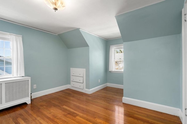 bonus room featuring baseboards, radiator heating unit, and wood finished floors
