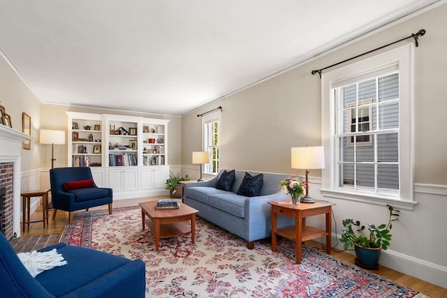 living area featuring crown molding, a fireplace, and wood finished floors