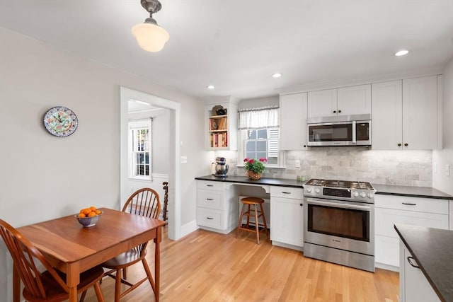 kitchen with white cabinetry, appliances with stainless steel finishes, dark countertops, and tasteful backsplash