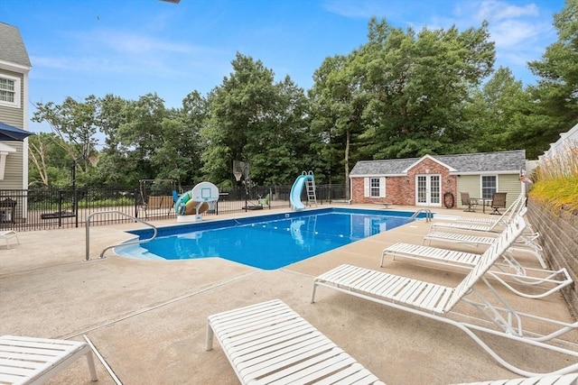 2 Dana Dr, Groveland, MA 01834 - view of pool with a water slide, a patio, view of wooded area, and an outbuilding