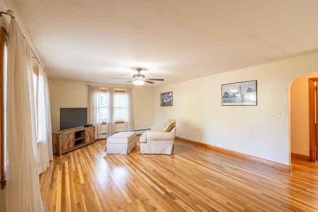 60 Highland Ave, Leominster, MA 01453 - living area featuring arched walkways, light wood-style flooring, a ceiling fan, and baseboards