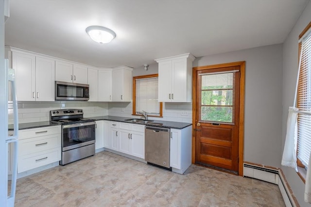 60 Highland Ave, Leominster, MA 01453 - kitchen featuring appliances with stainless steel finishes, dark countertops, a sink, and tasteful backsplash