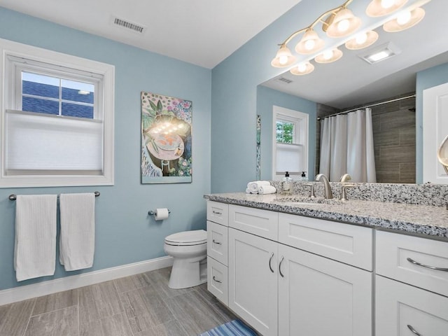 83 Boynton St, Waltham, MA 02453 - bathroom with baseboards, toilet, vanity, and a shower with curtain