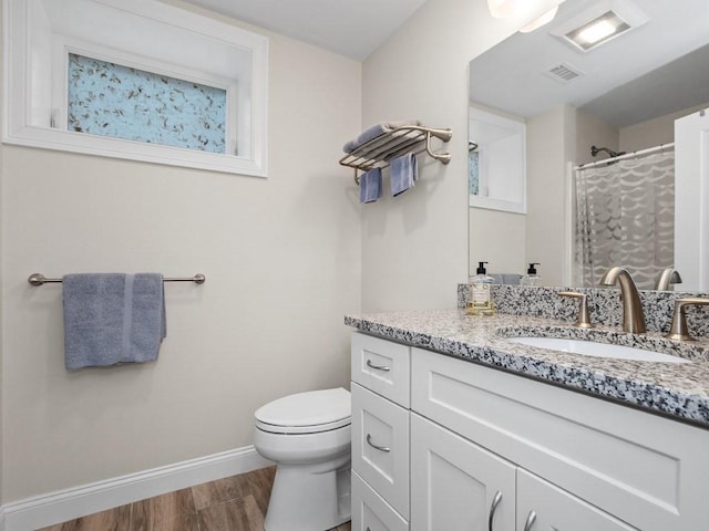 83 Boynton St, Waltham, MA 02453 - full bathroom featuring wood finished floors, toilet, baseboards, a shower with curtain, and vanity