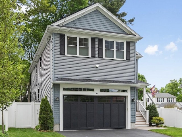 83 Boynton St, Waltham, MA 02453 - view of front facade with fence, a garage, and driveway