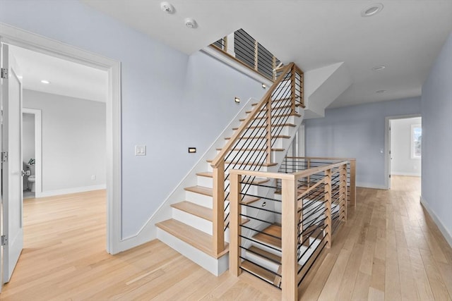 staircase with recessed lighting, baseboards, and wood finished floors