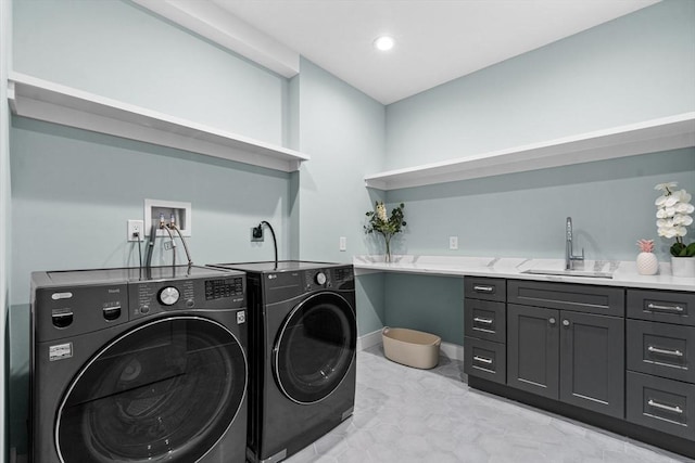 clothes washing area featuring cabinet space, baseboards, washing machine and dryer, a sink, and recessed lighting