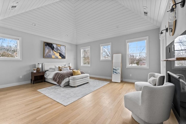 bedroom with light wood finished floors, multiple windows, wood ceiling, and baseboards