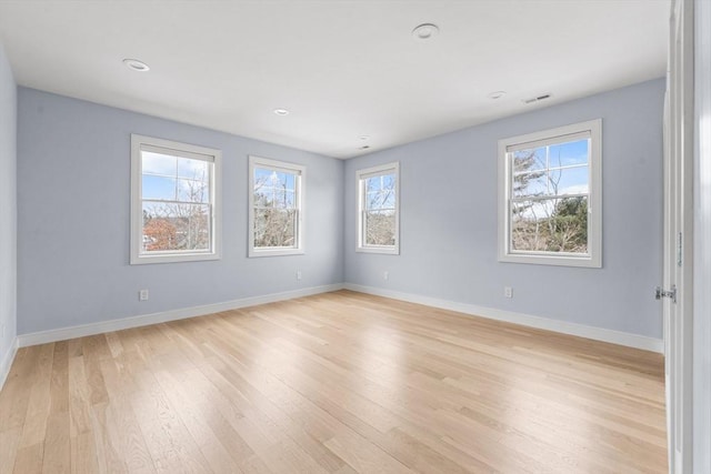 unfurnished room with light wood-type flooring, visible vents, baseboards, and recessed lighting