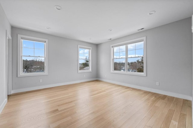 unfurnished room featuring light wood-style flooring, visible vents, baseboards, and recessed lighting