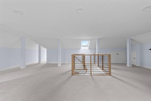 bonus room with vaulted ceiling with skylight, baseboards, and light colored carpet